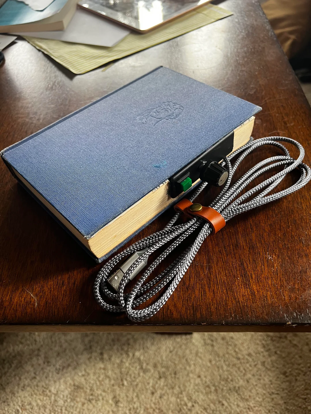 Tome Reader ereader device open, showing the e-paper display with a book loaded